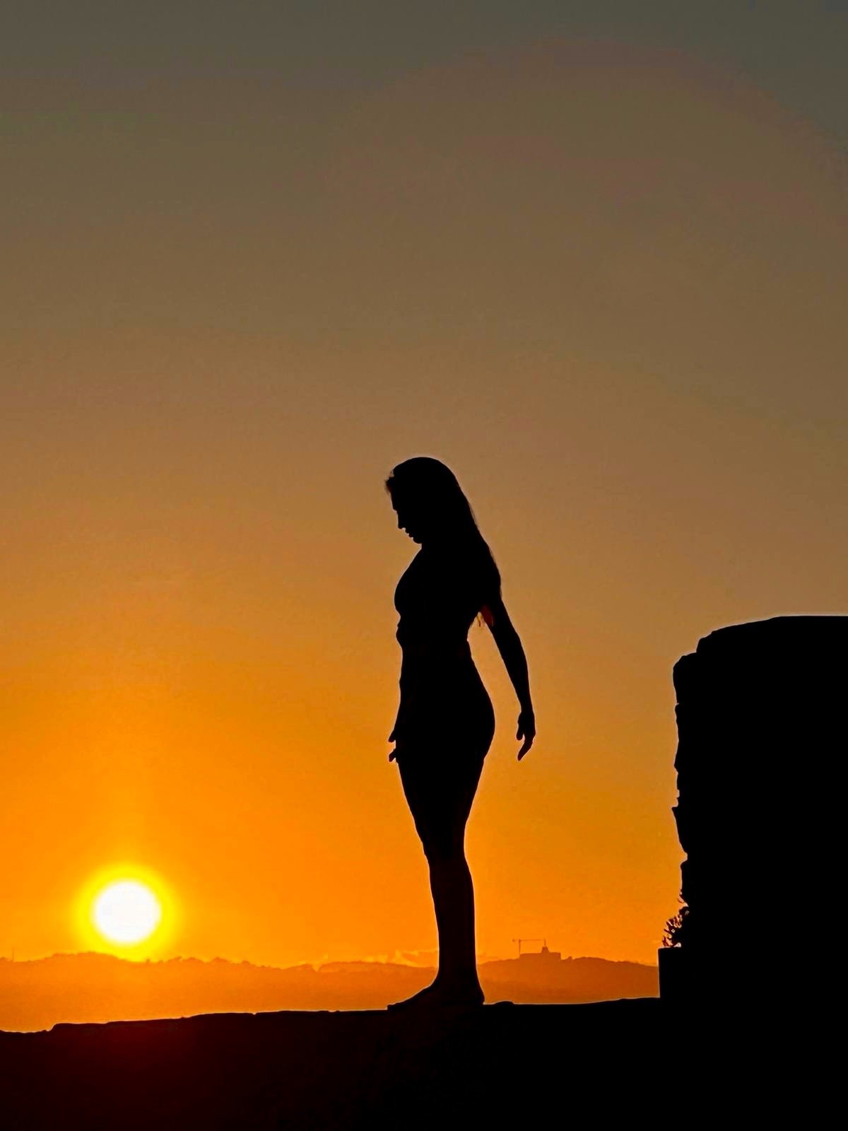 Silhouette debout dans la lumière d’un coucher de soleil.