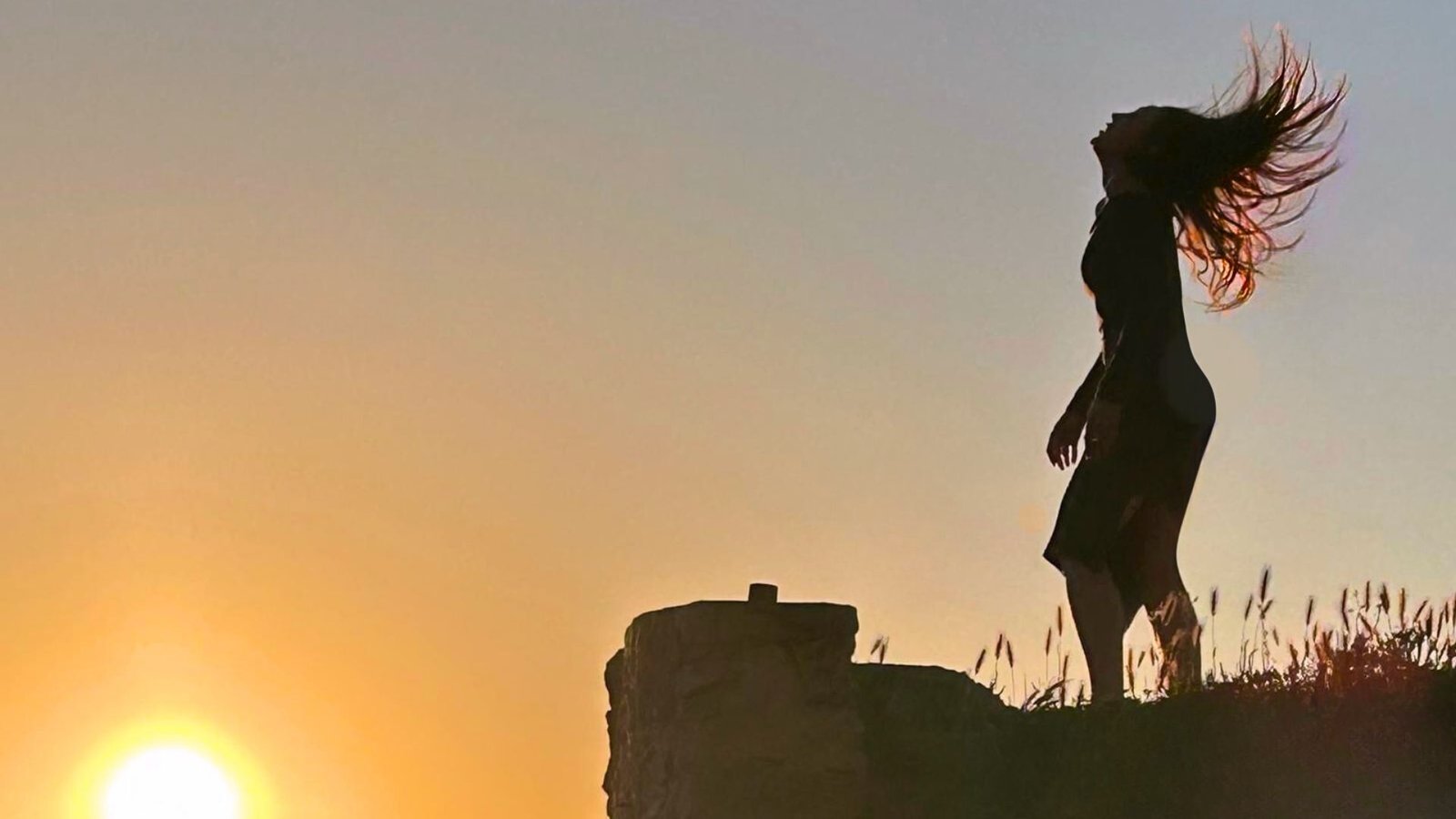 Silhouette en mouvement face au soleil couchant.